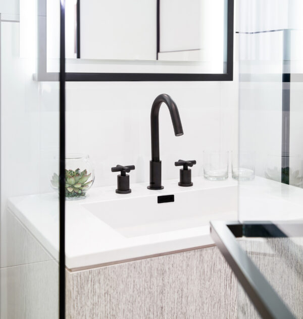 Modern bathroom sink with black faucet and glass accents.