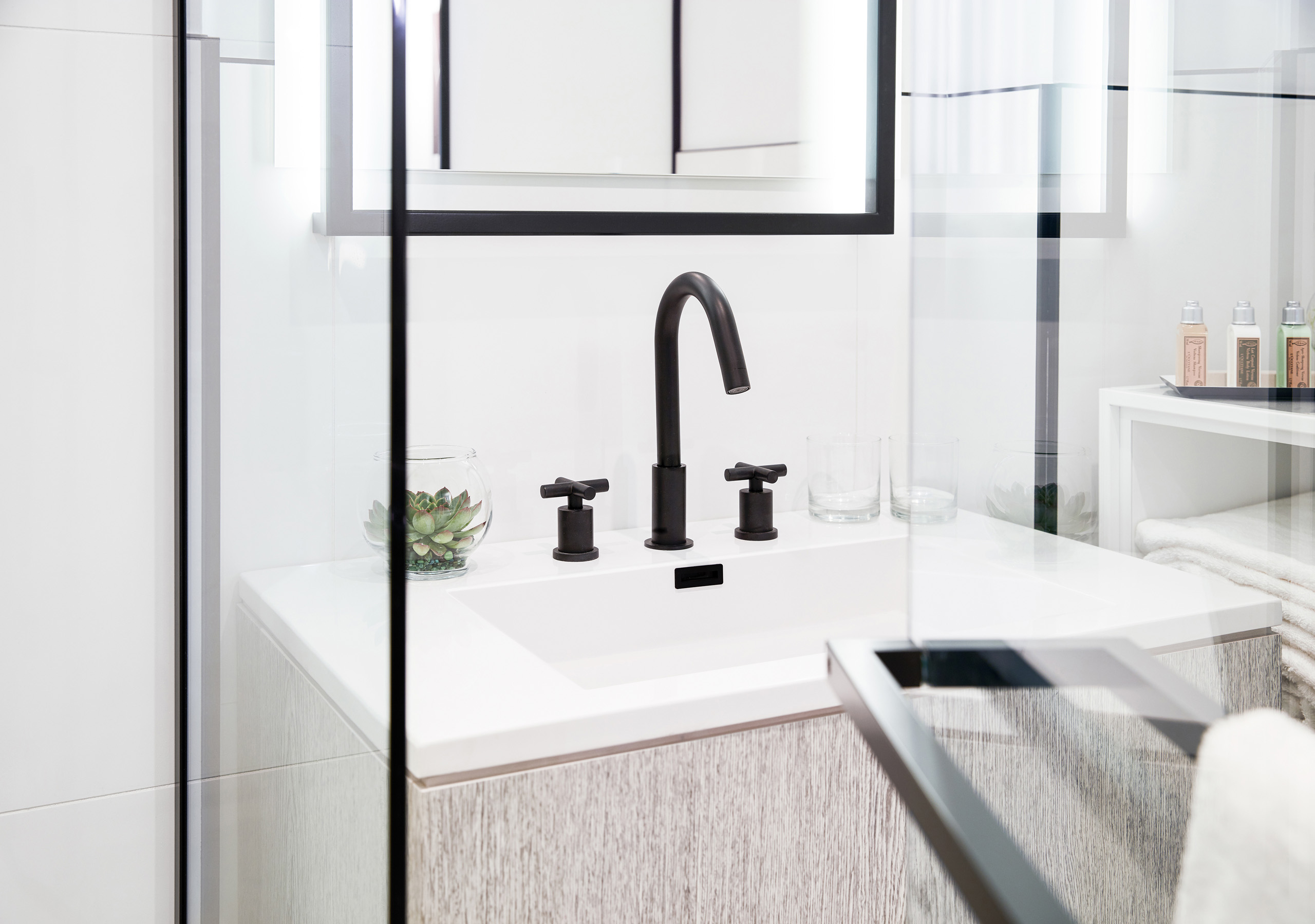Modern bathroom sink with black faucet and glass accents.