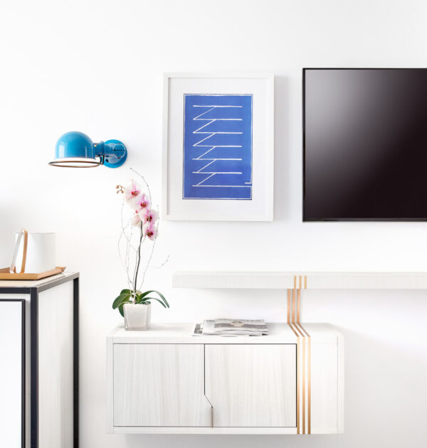 Coffee station, orchid, and TV in modern hotel room.