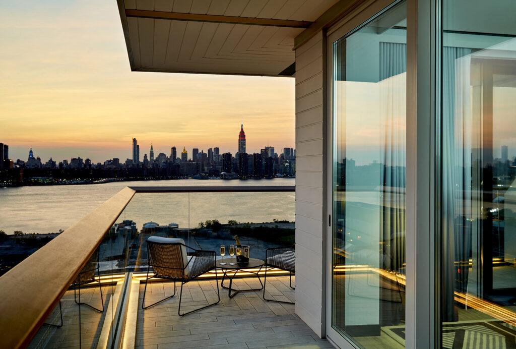 Sunset balcony view with chairs and champagne setup.