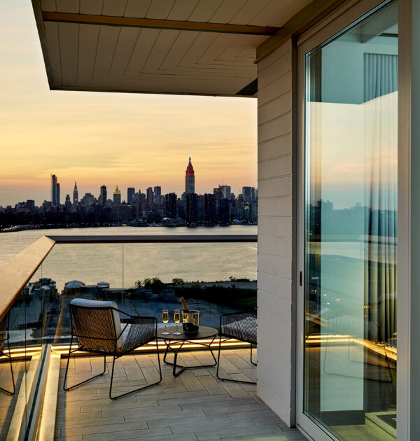 Sunset balcony view with chairs and champagne setup.