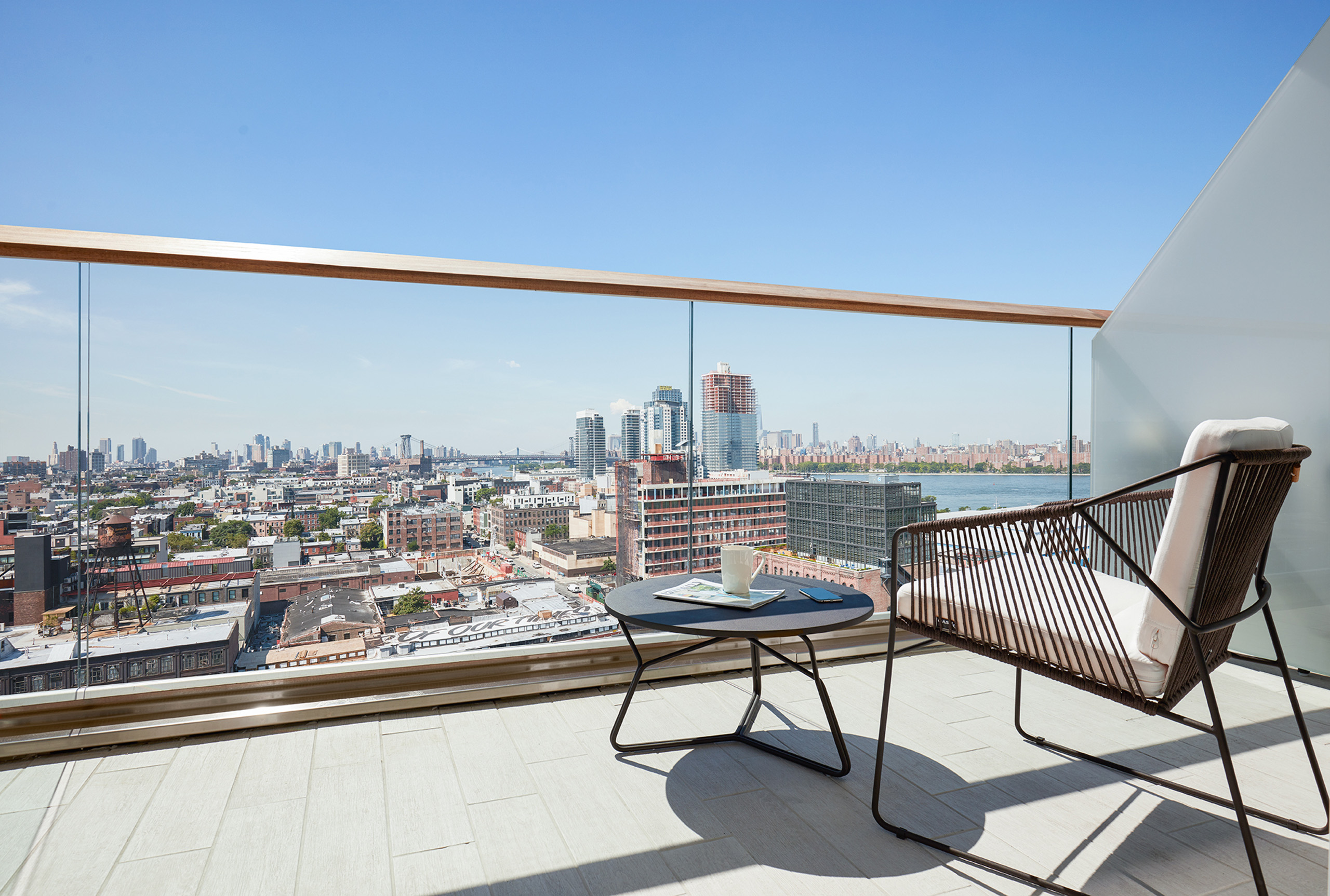 About 4 Balcony with city view, chair, and coffee table.