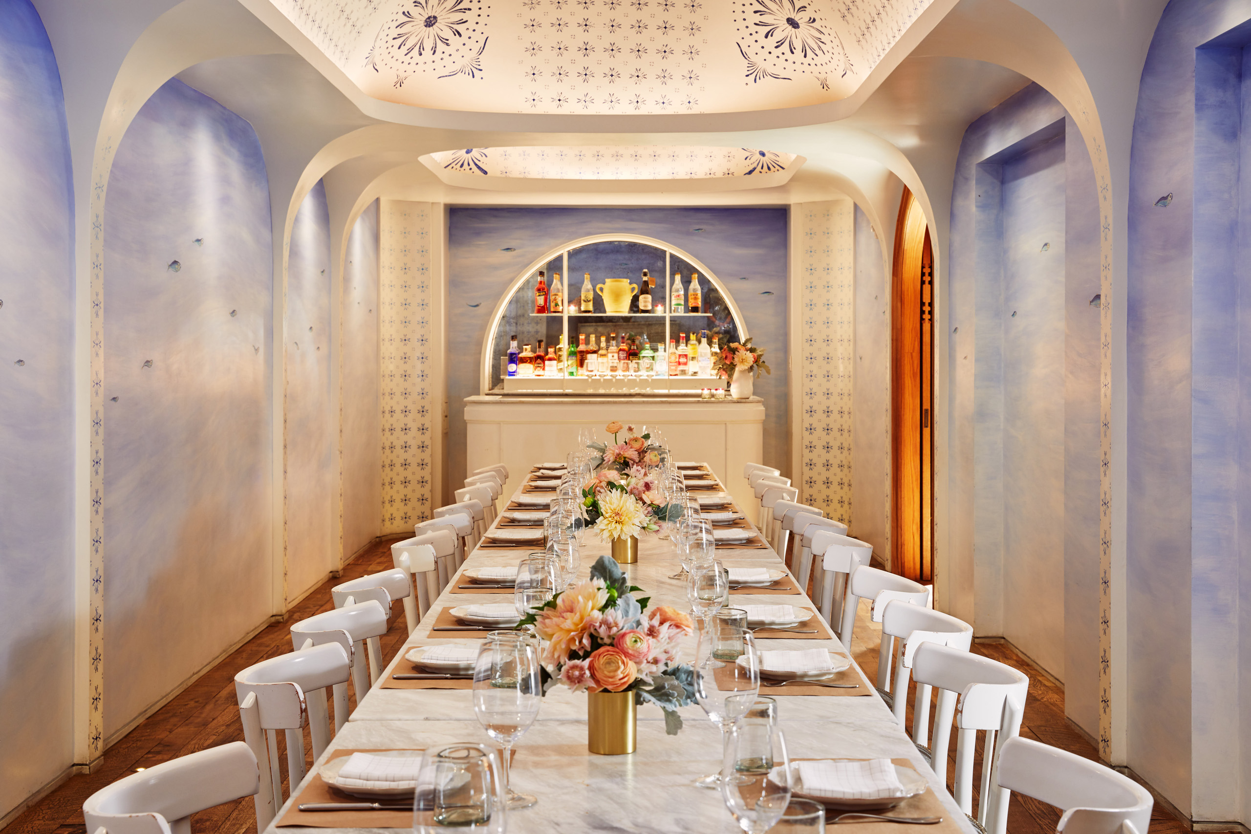 Elegant private dining room with marble table and bar.