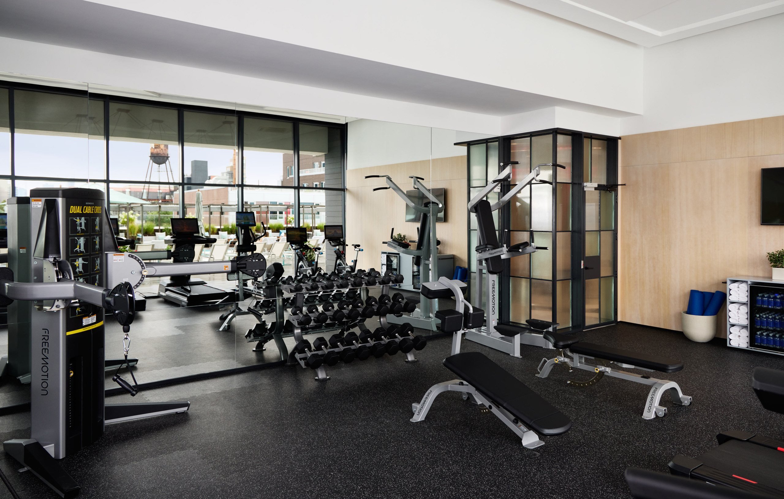 Indoor gym with weight machines, free weights, and treadmills.