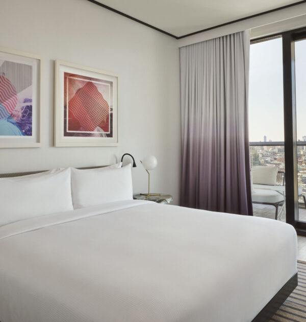 Stylish bedroom with art and skyline view balcony.