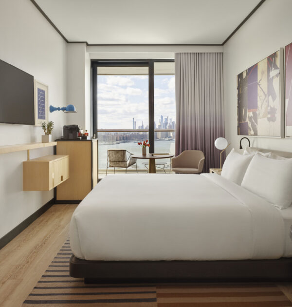 King guest room with balcony and Manhattan skyline view.