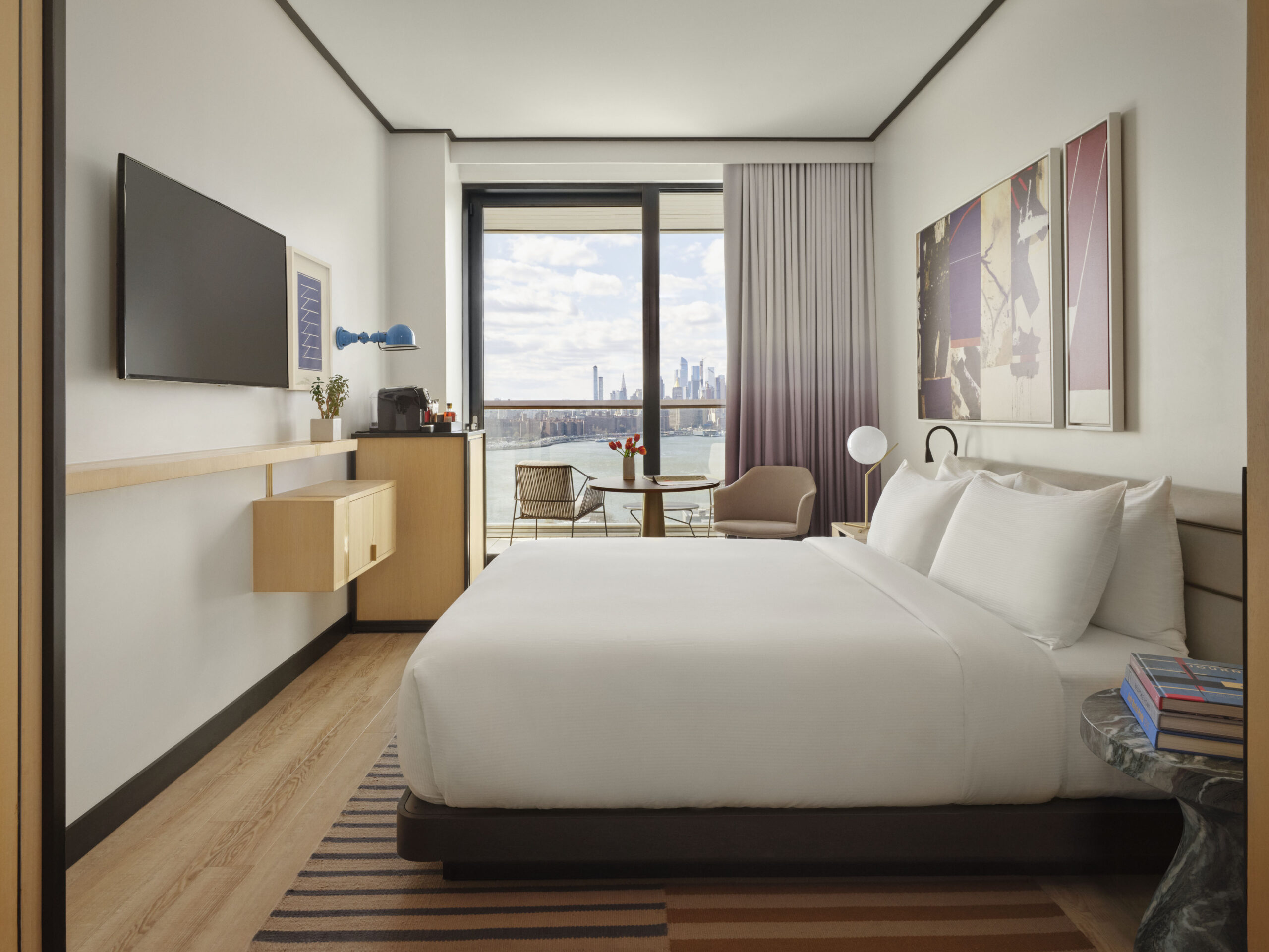 King guest room with balcony and Manhattan skyline view.