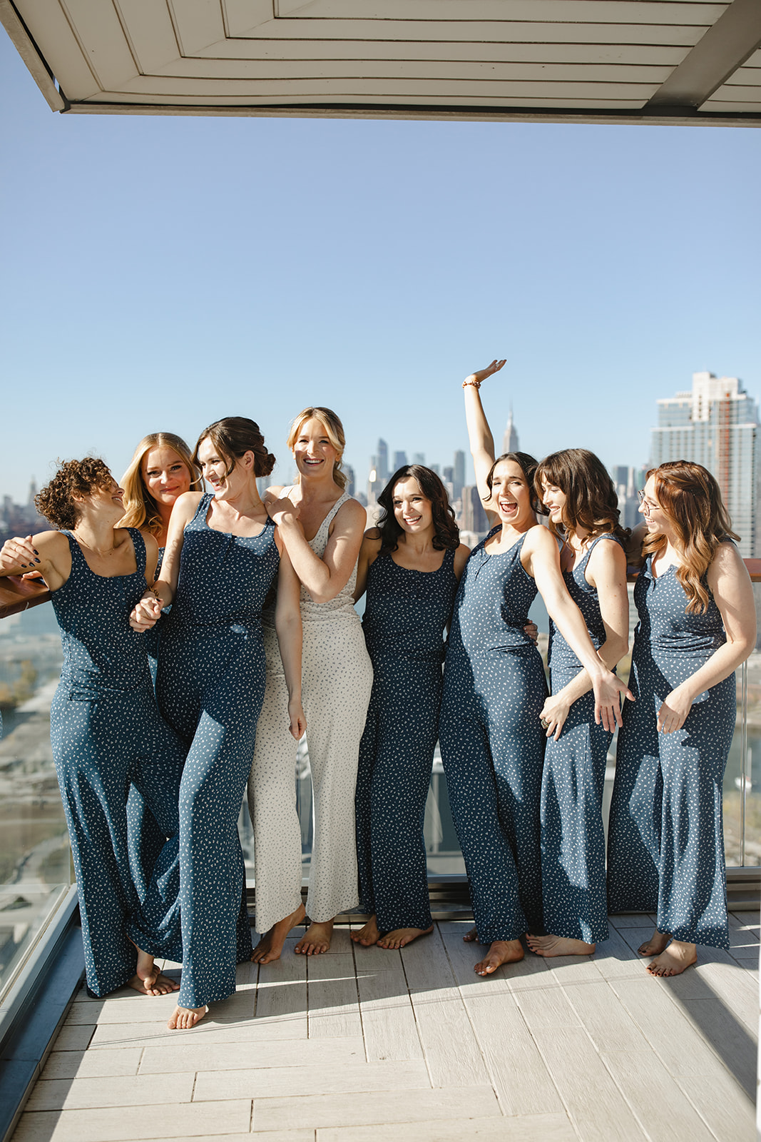 Bridesmaids in matching pajamas on rooftop deck.