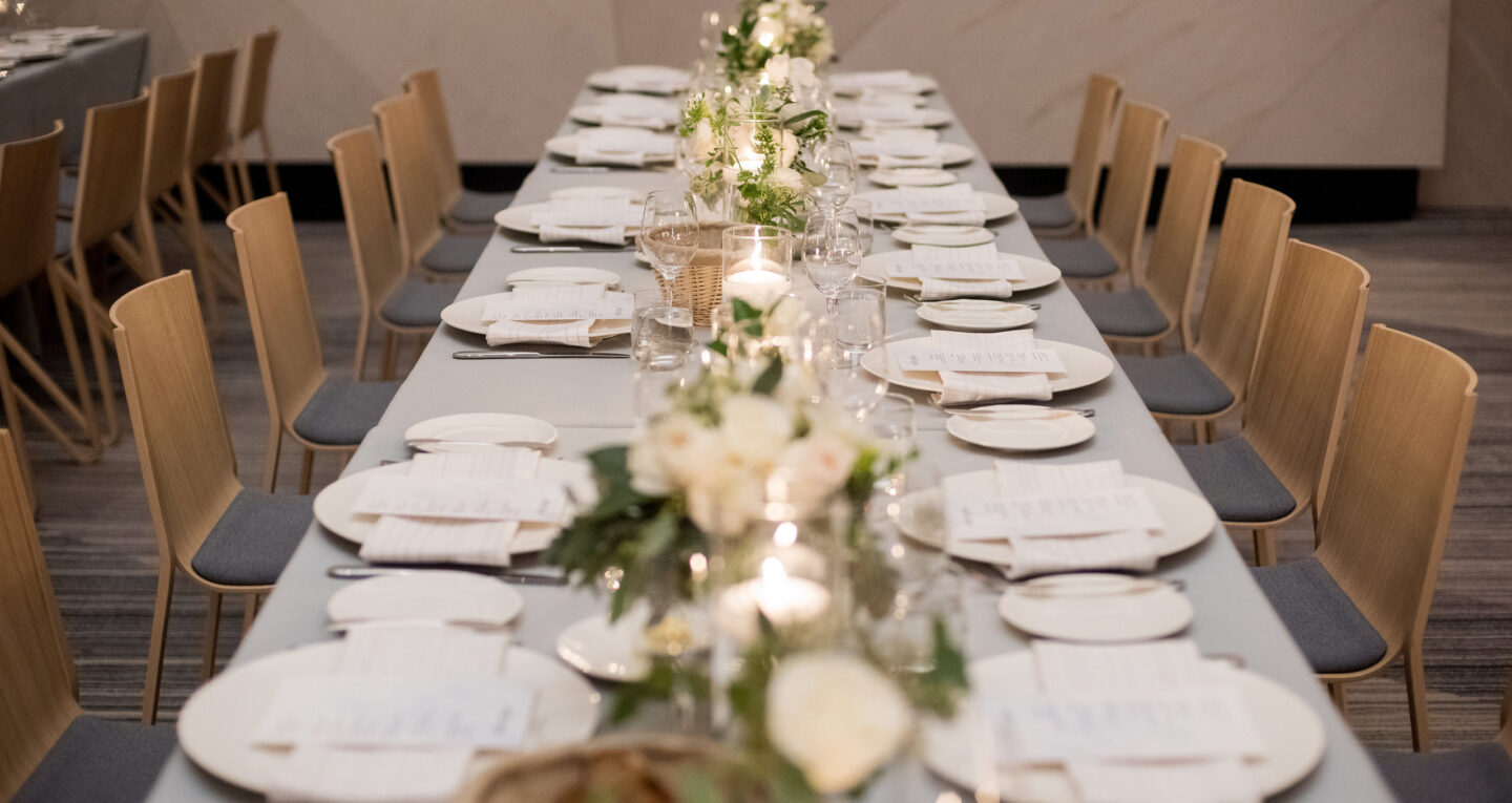 Long banquet table with formal place settings.