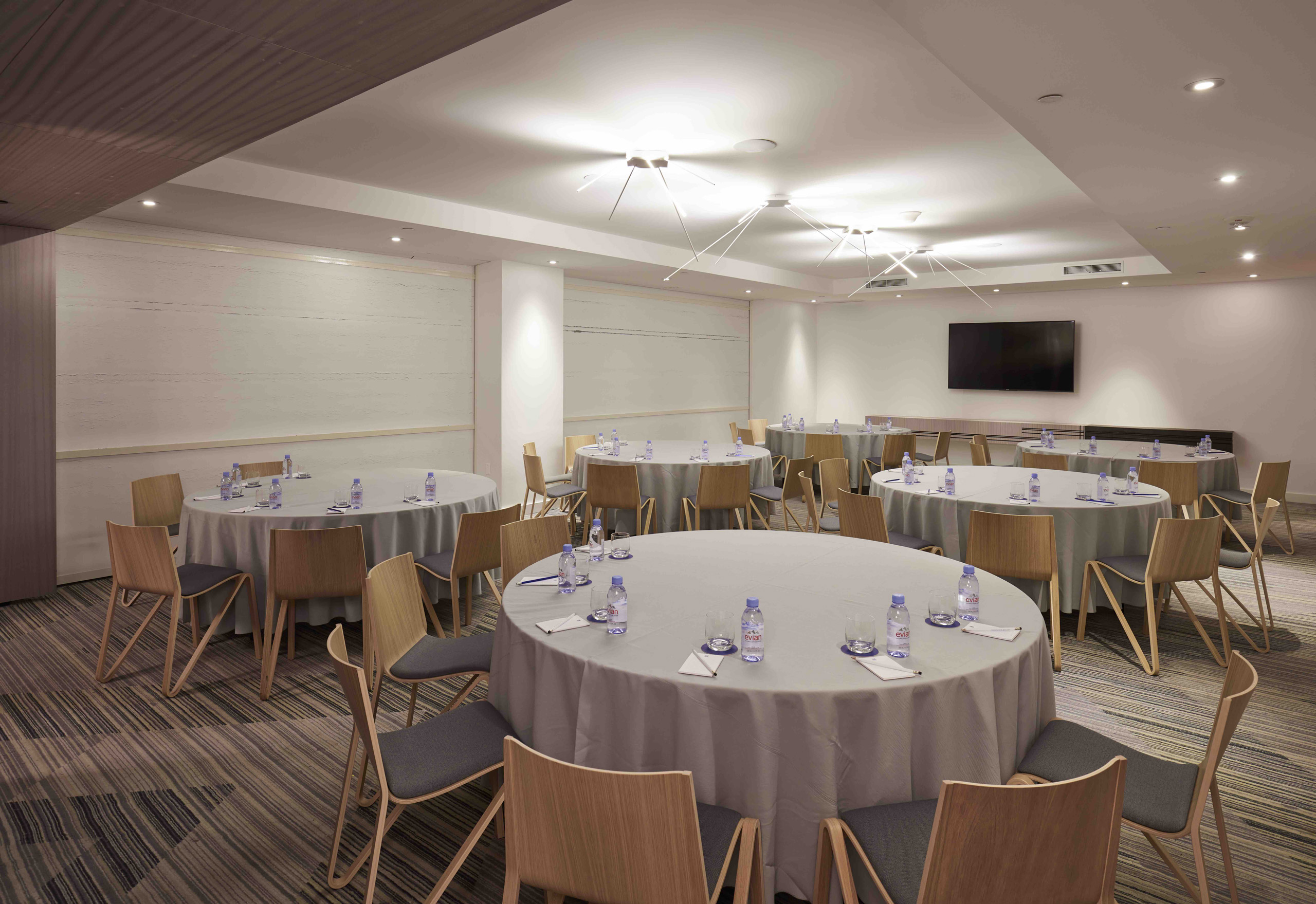 Theater-style conference room setup with rows of wooden chairs.