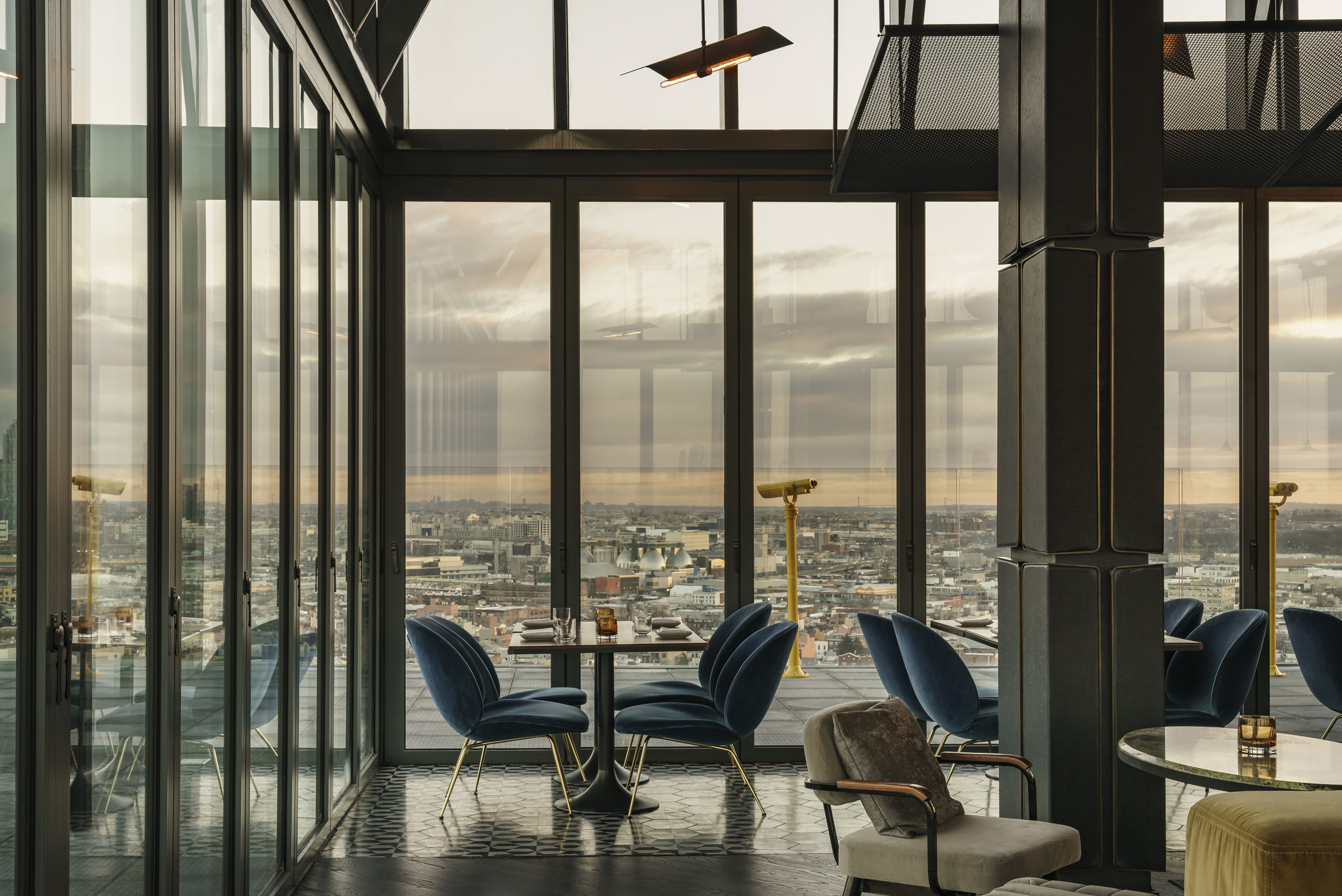 Elegant rooftop dining area with panoramic city views at sunset.