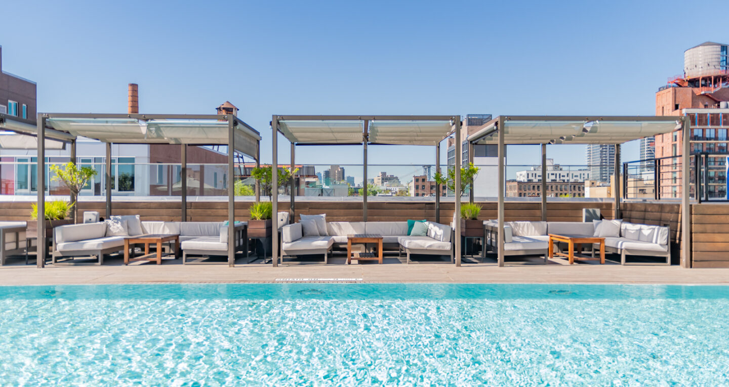 Rooftop pool with shaded cabanas and lounge seating.