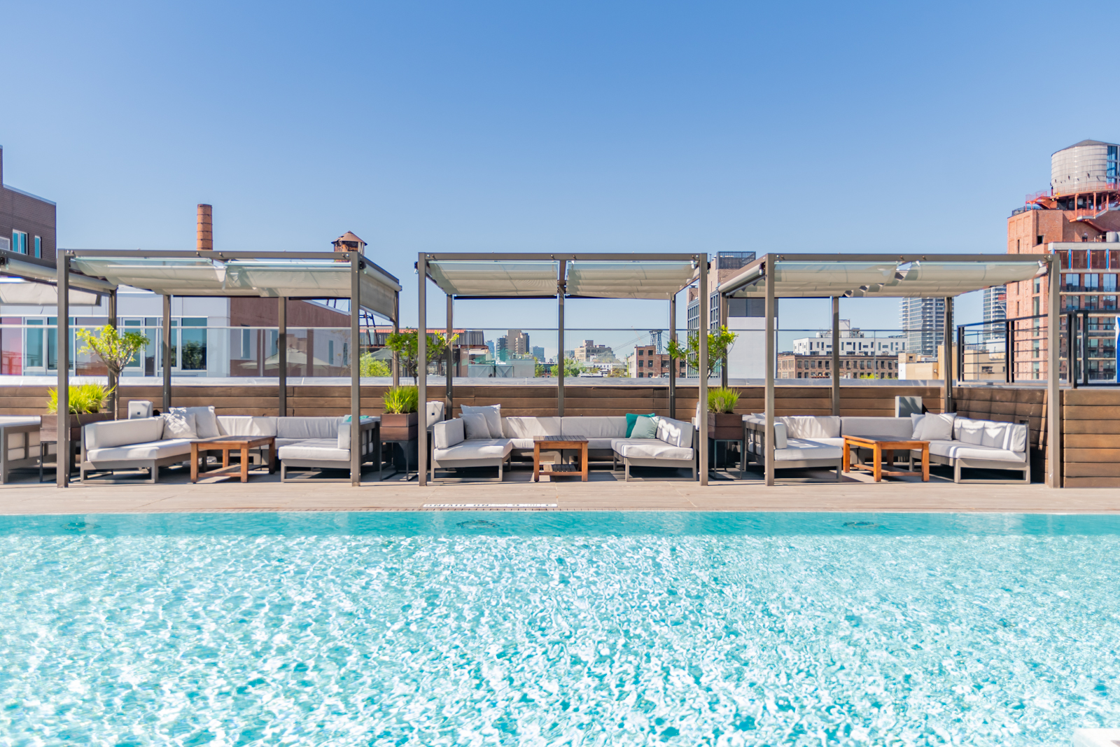 Rooftop pool with shaded cabanas and lounge seating.