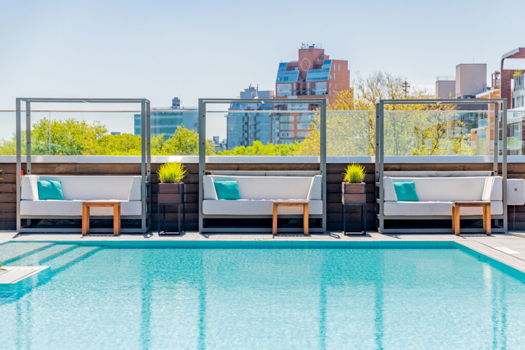 Rooftop poolside cabanas with turquoise accent pillows.
