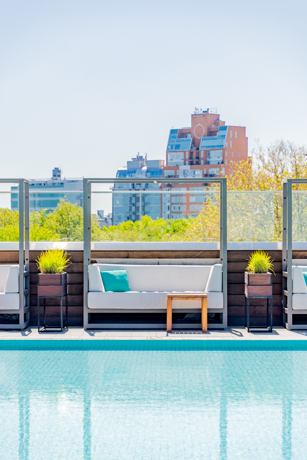 Rooftop poolside cabana with modern city view.
