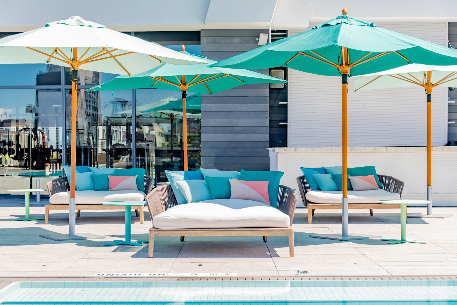 Lounge chairs and umbrellas beside pool.