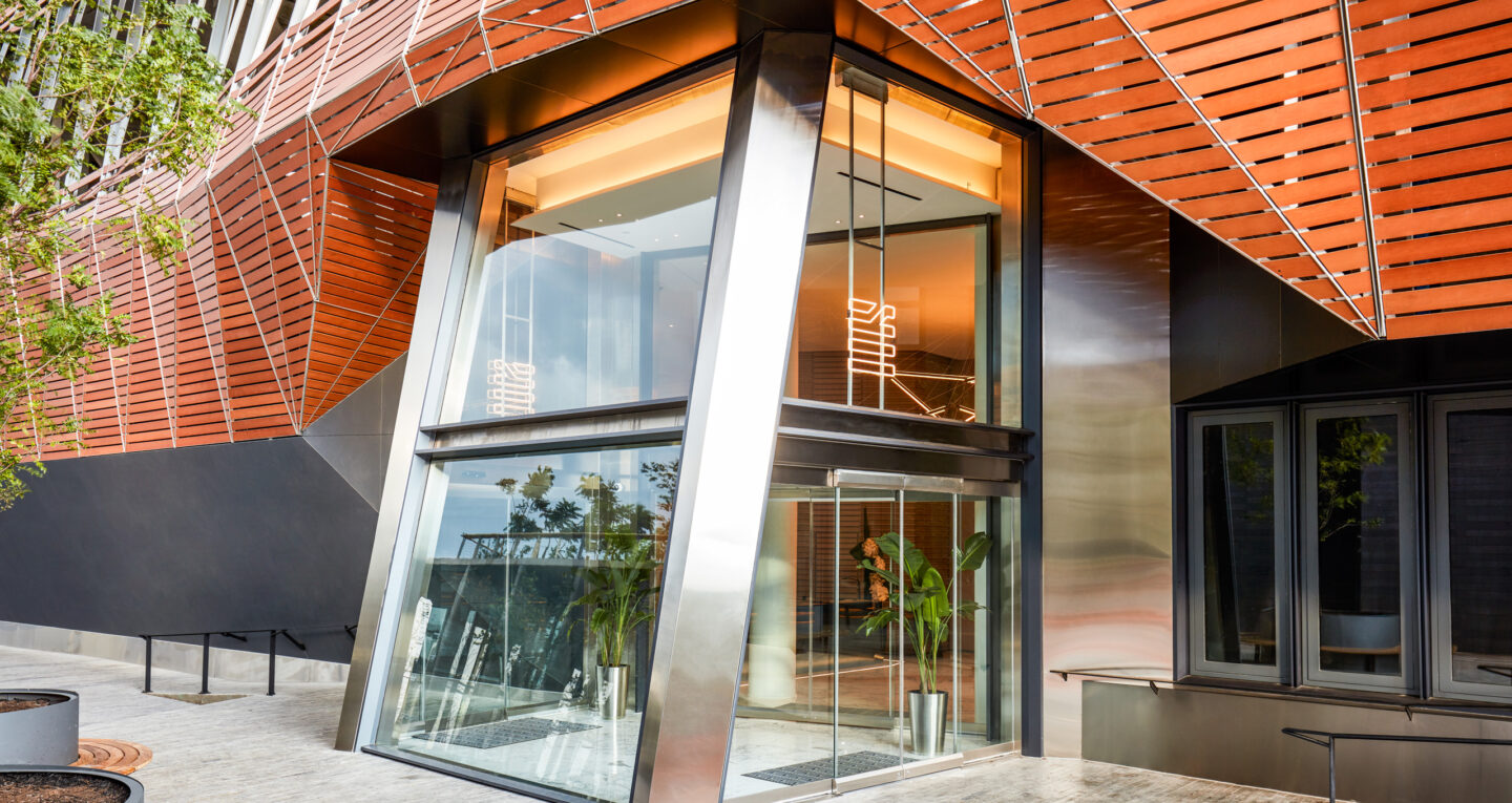 Modern glass entrance with orange architectural paneling.