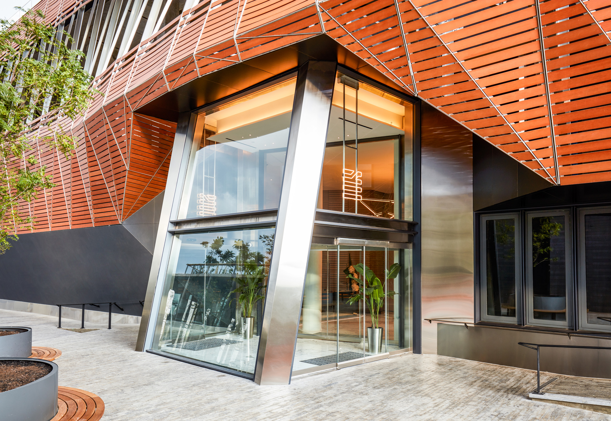 Modern glass entrance with orange architectural paneling.