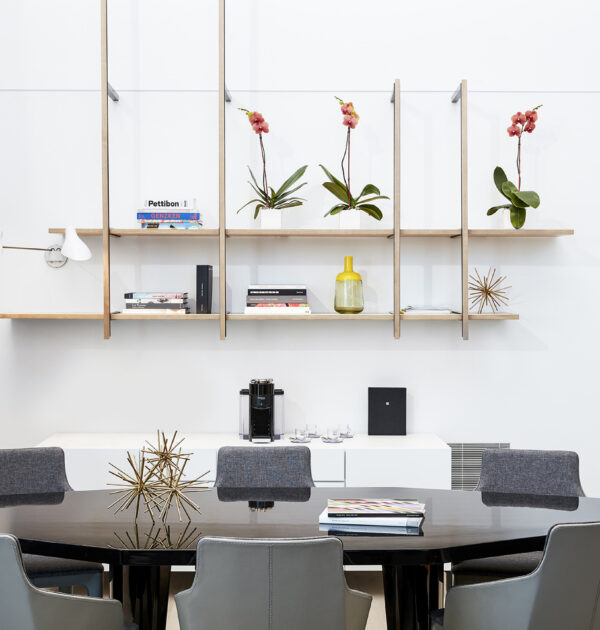 Dining room with decorative shelves and orchid arrangements.