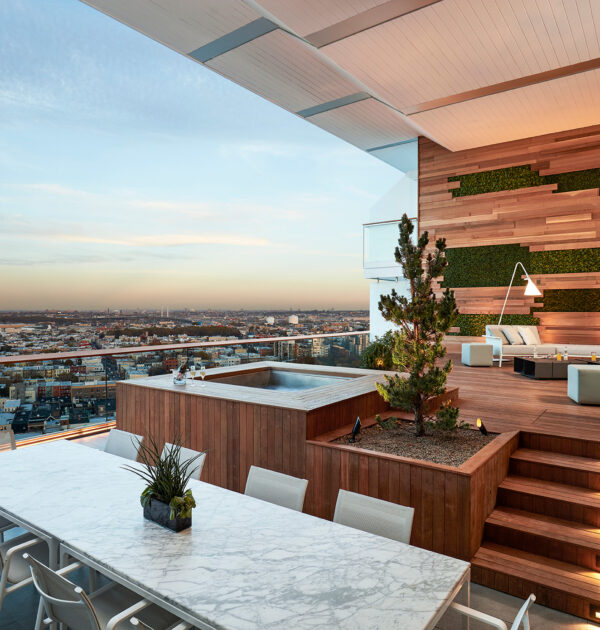 Rooftop terrace with marble dining table, hot tub, and city view.