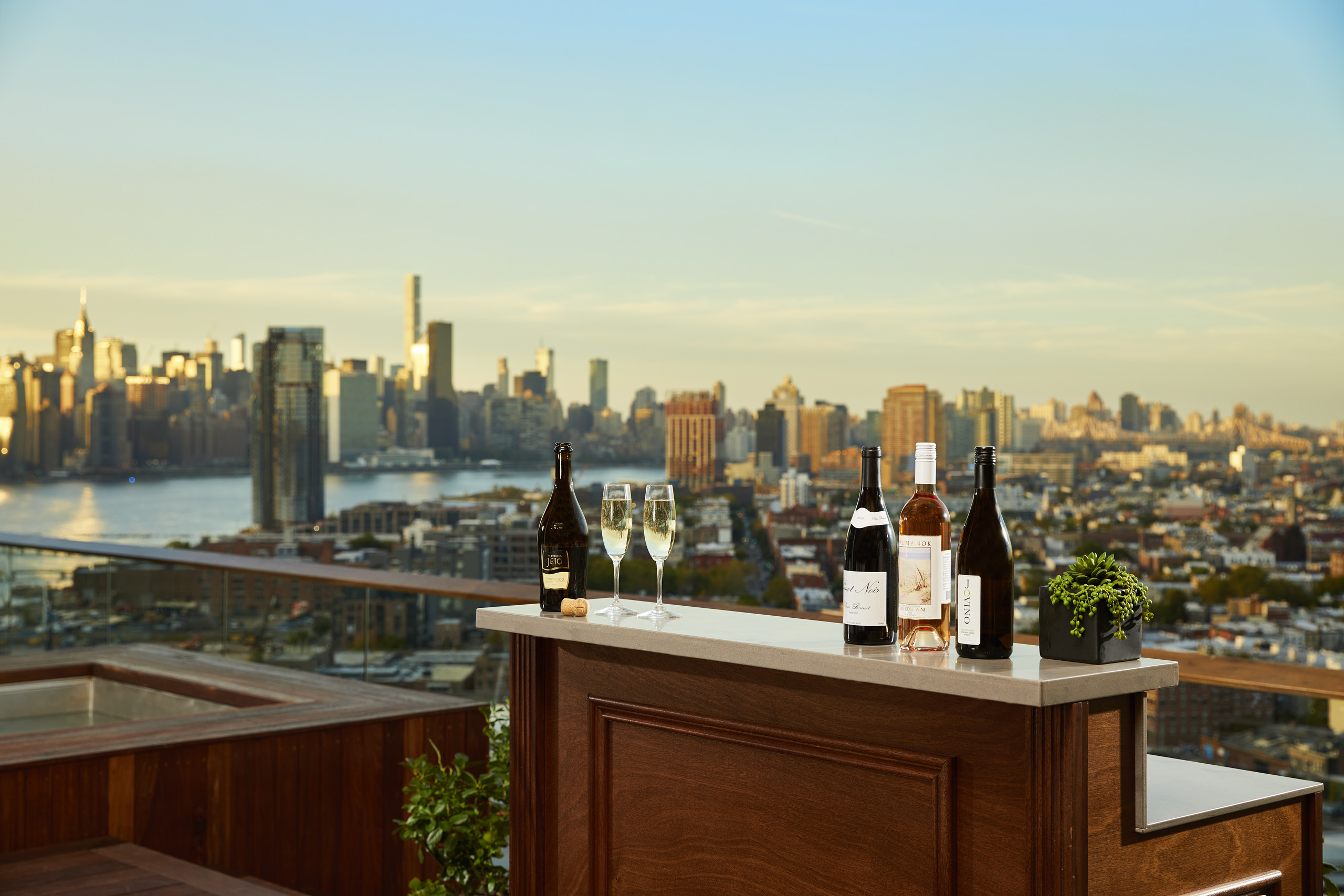 Rooftop bar with wine bottles and skyline view.