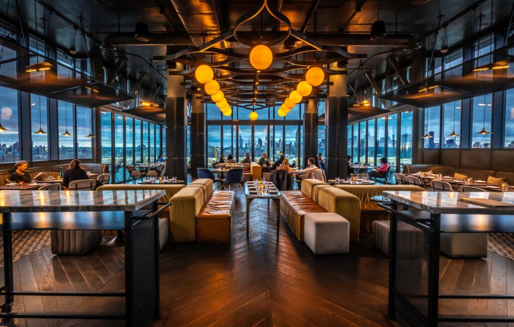 Rooftop bar with panoramic city views at sunset.