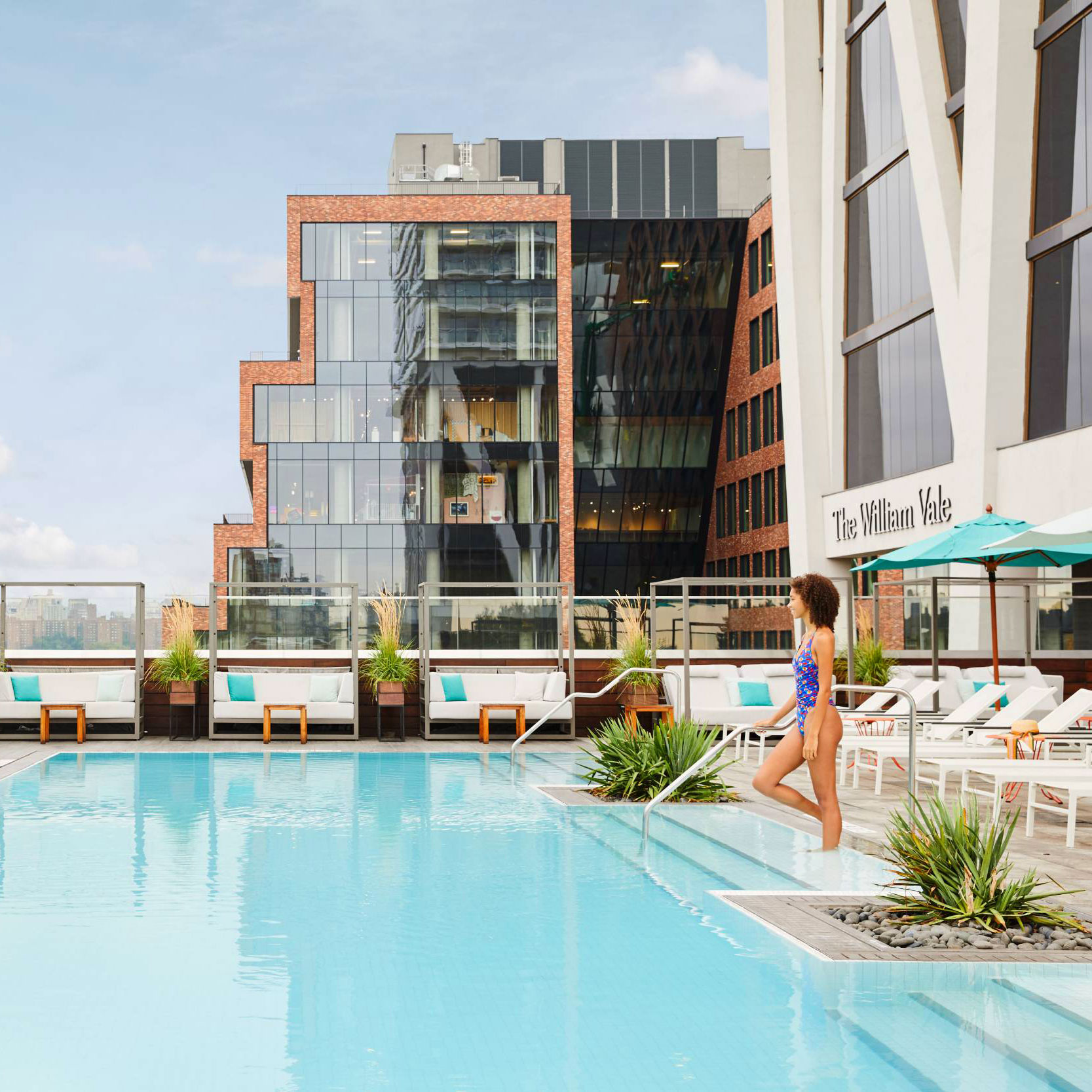 Woman enters rooftop pool at The William Vale Hotel.