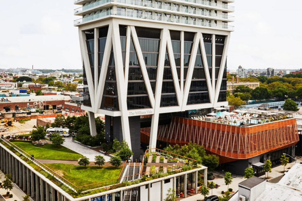 Book Direct and Save 1 Exterior view of tall modern hotel in cityscape setting