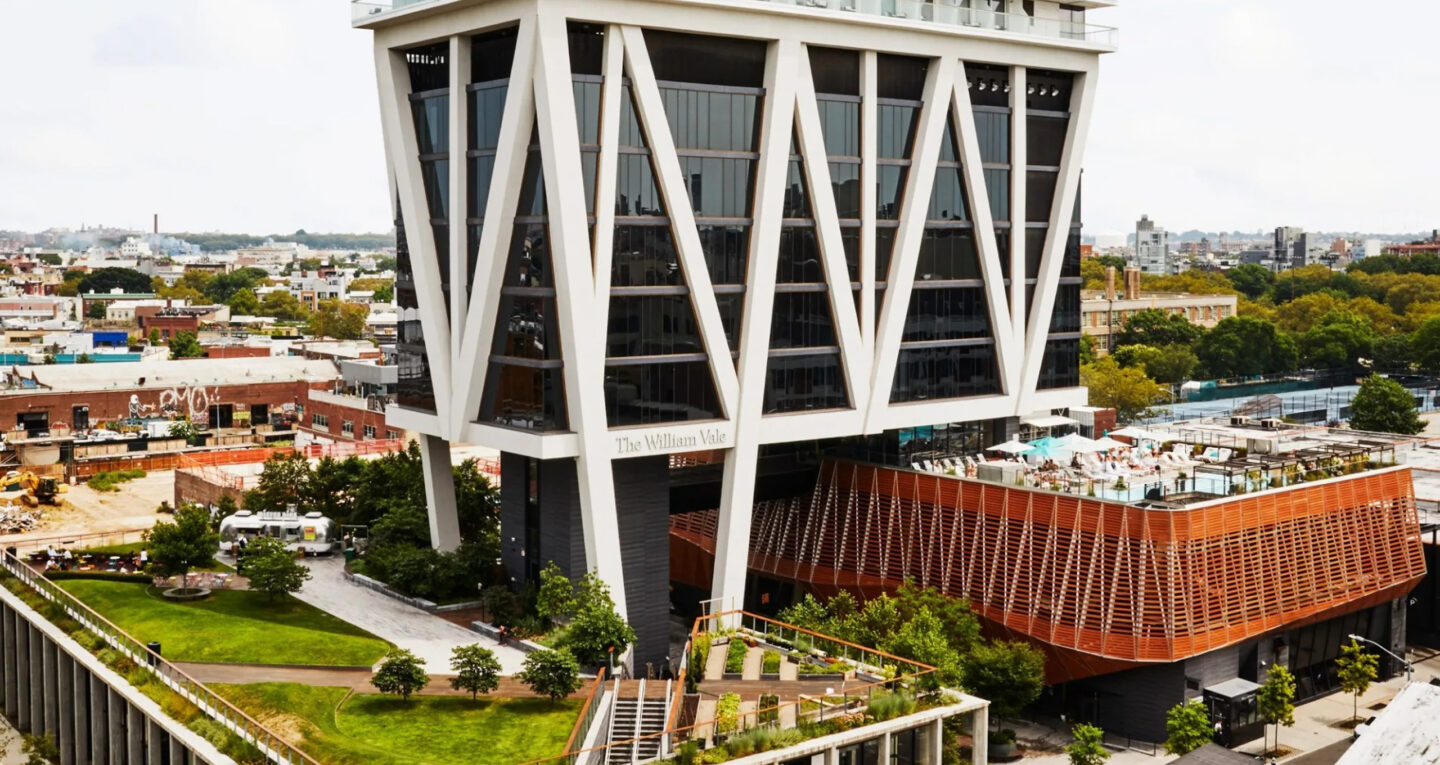 Exterior view of tall modern hotel in cityscape setting
