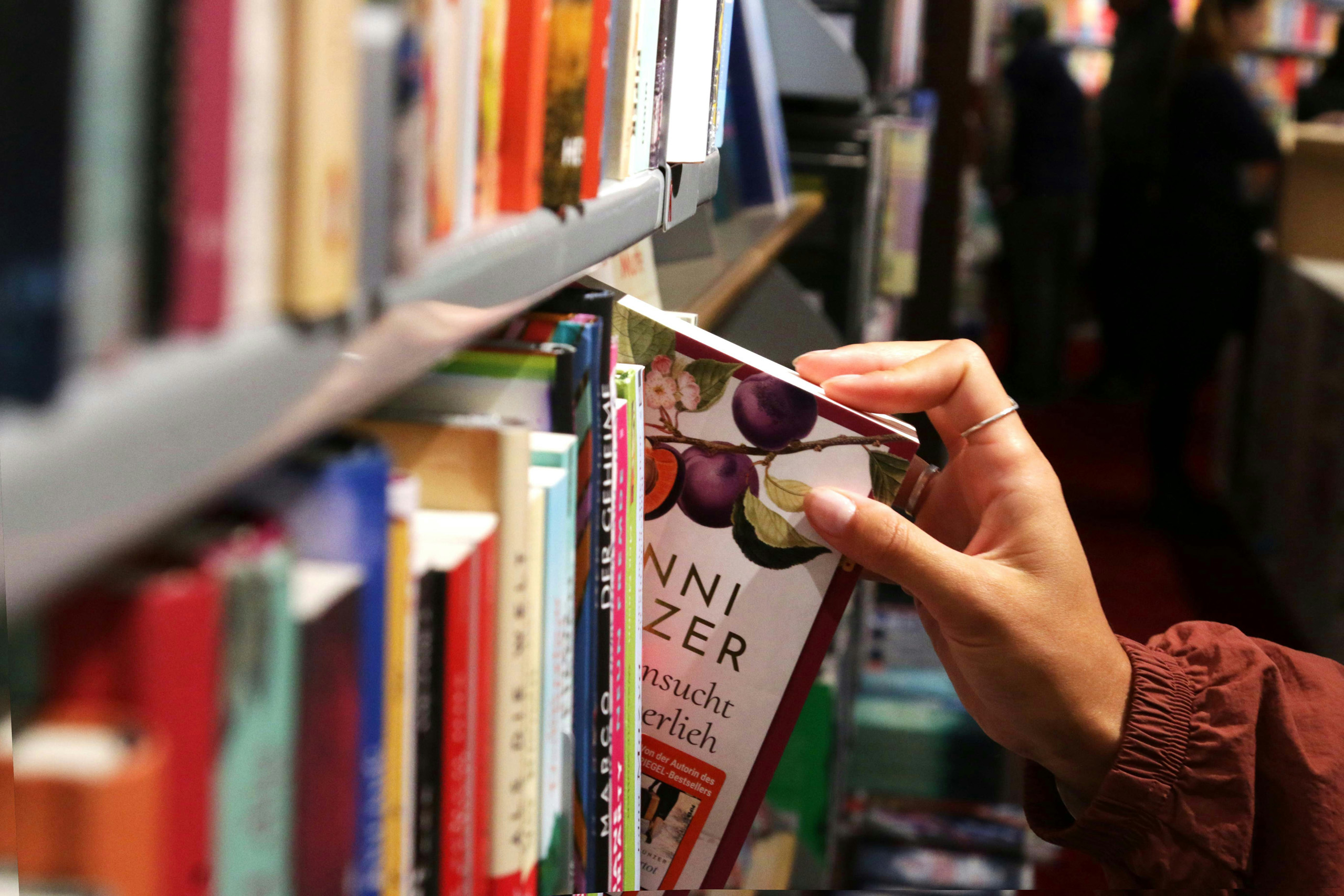 Hand pulling book from book store shelf