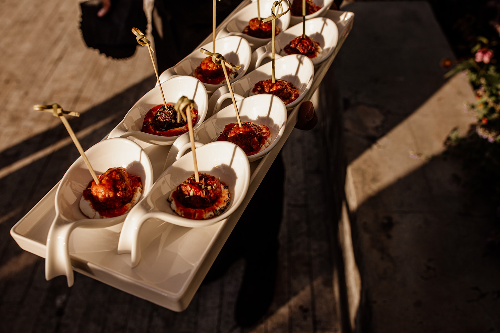 Parties 15 Tray of meatball appetizers served in white spoons with skewers.