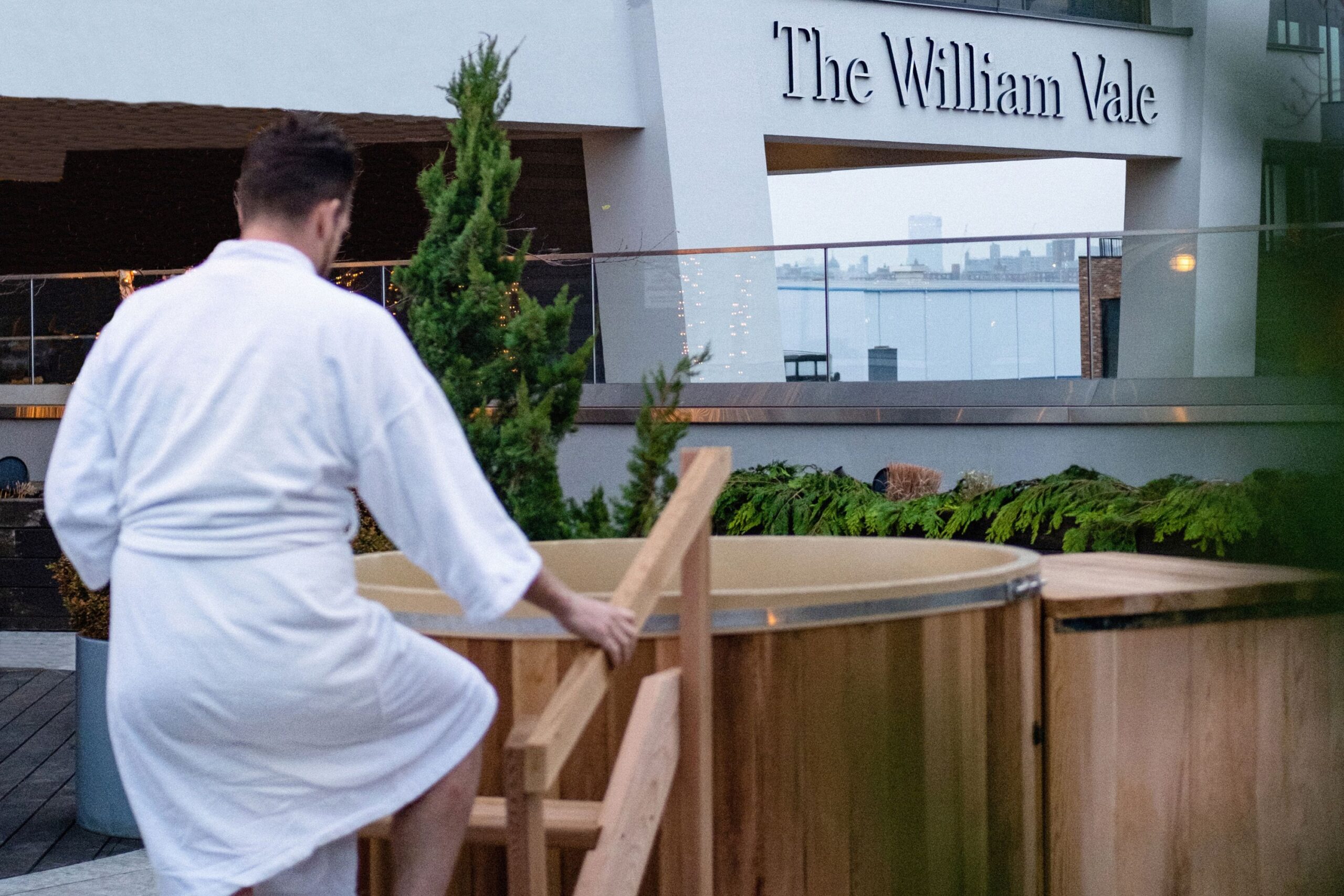 Man in robe approaching hot tub