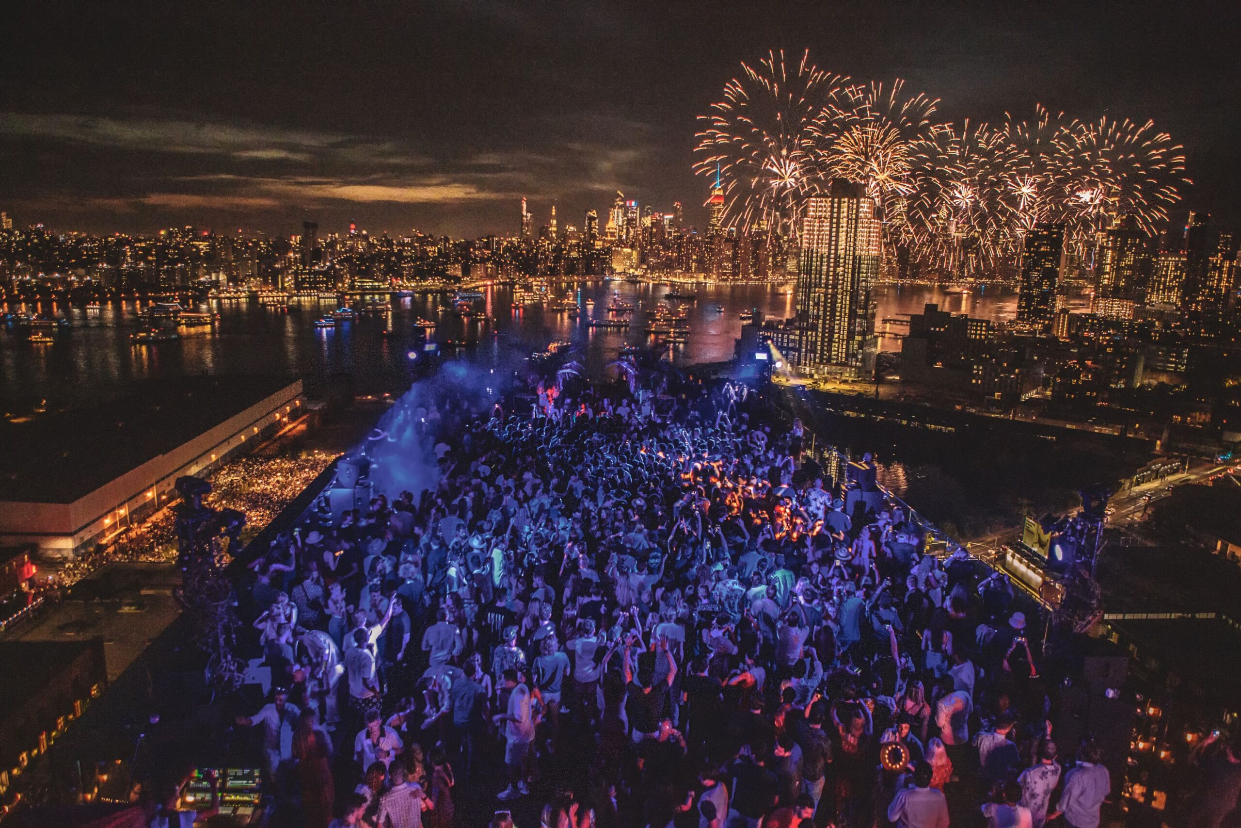 Fireworks over the Manhattan skyline from a rooftop party in Brooklyn.