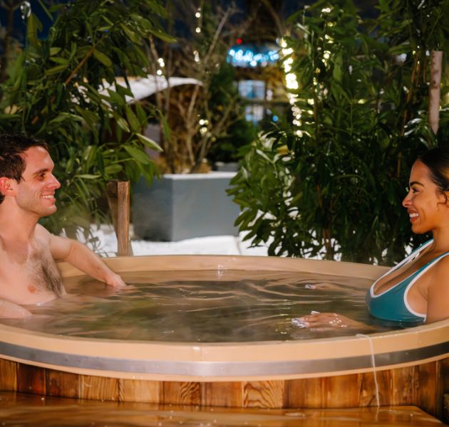 Two guests soak in deep-soaking cedar hot tub.