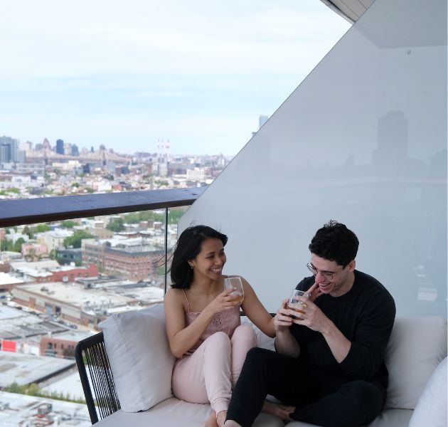 Couple laughs on their private balcony.