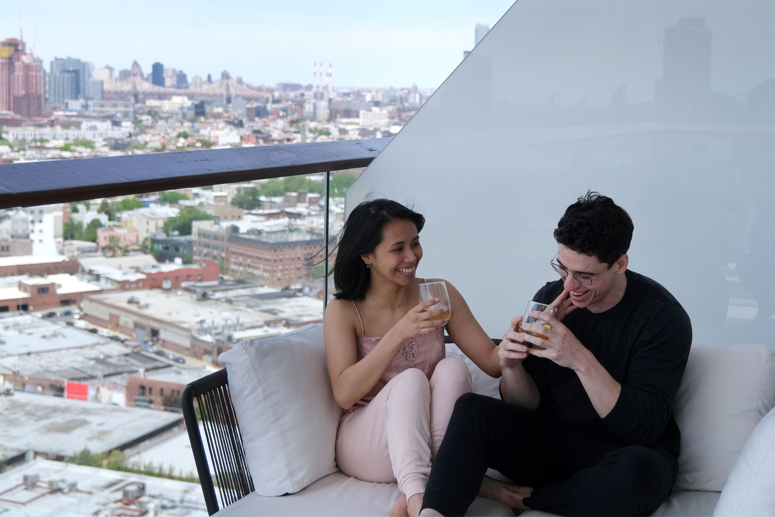 Guests sit on private balcony, drinking wine and laughing.