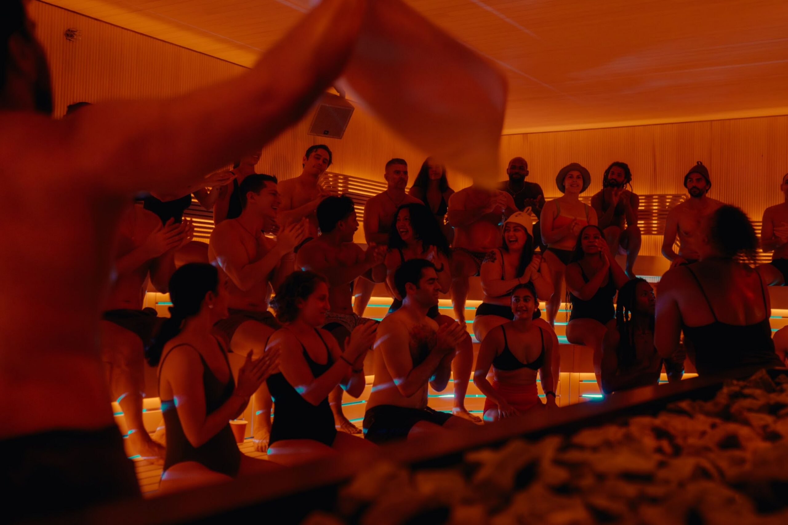 Guests enjoy sauna while guide waves scents around with towel.