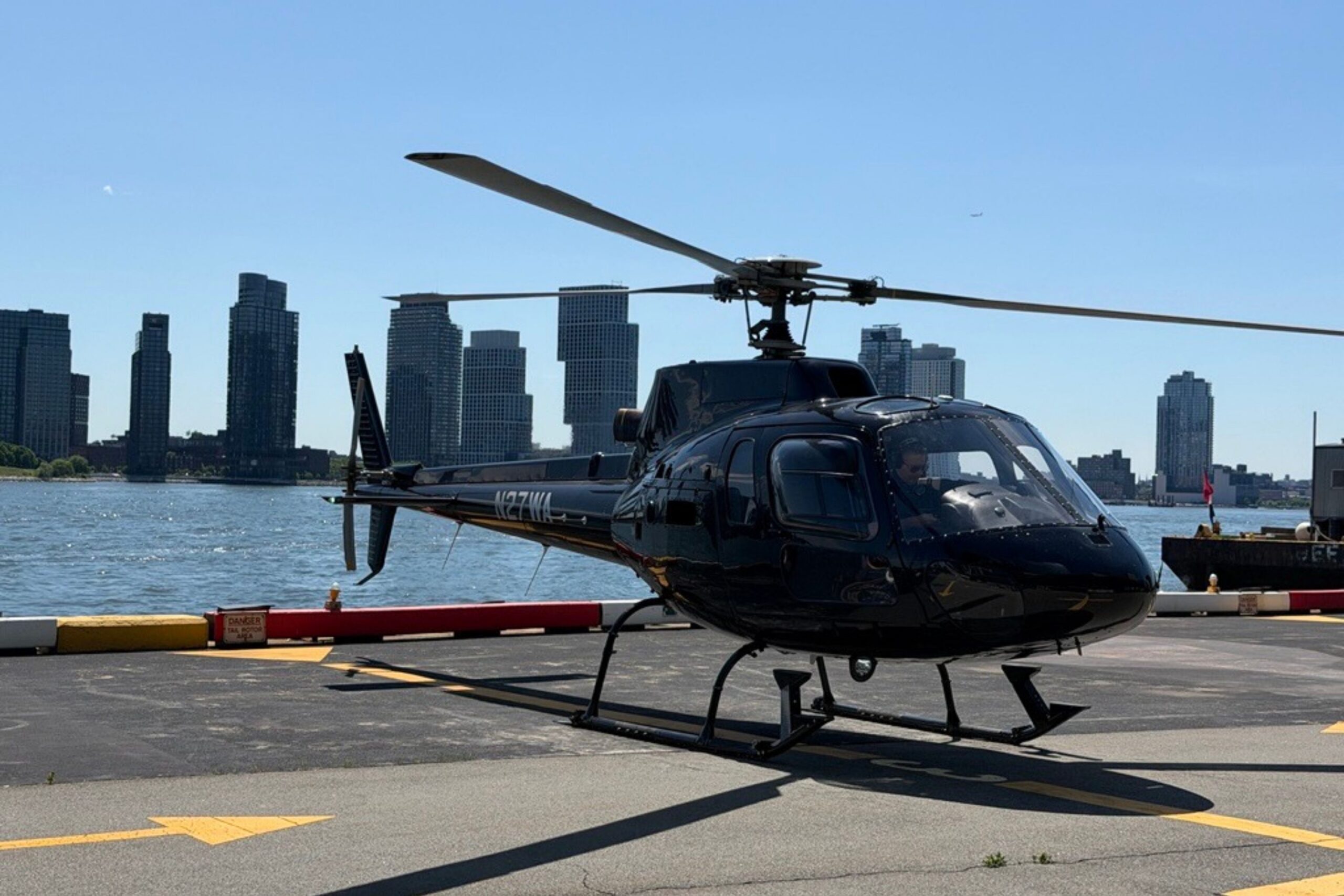 Helicopter sits on helipad near river