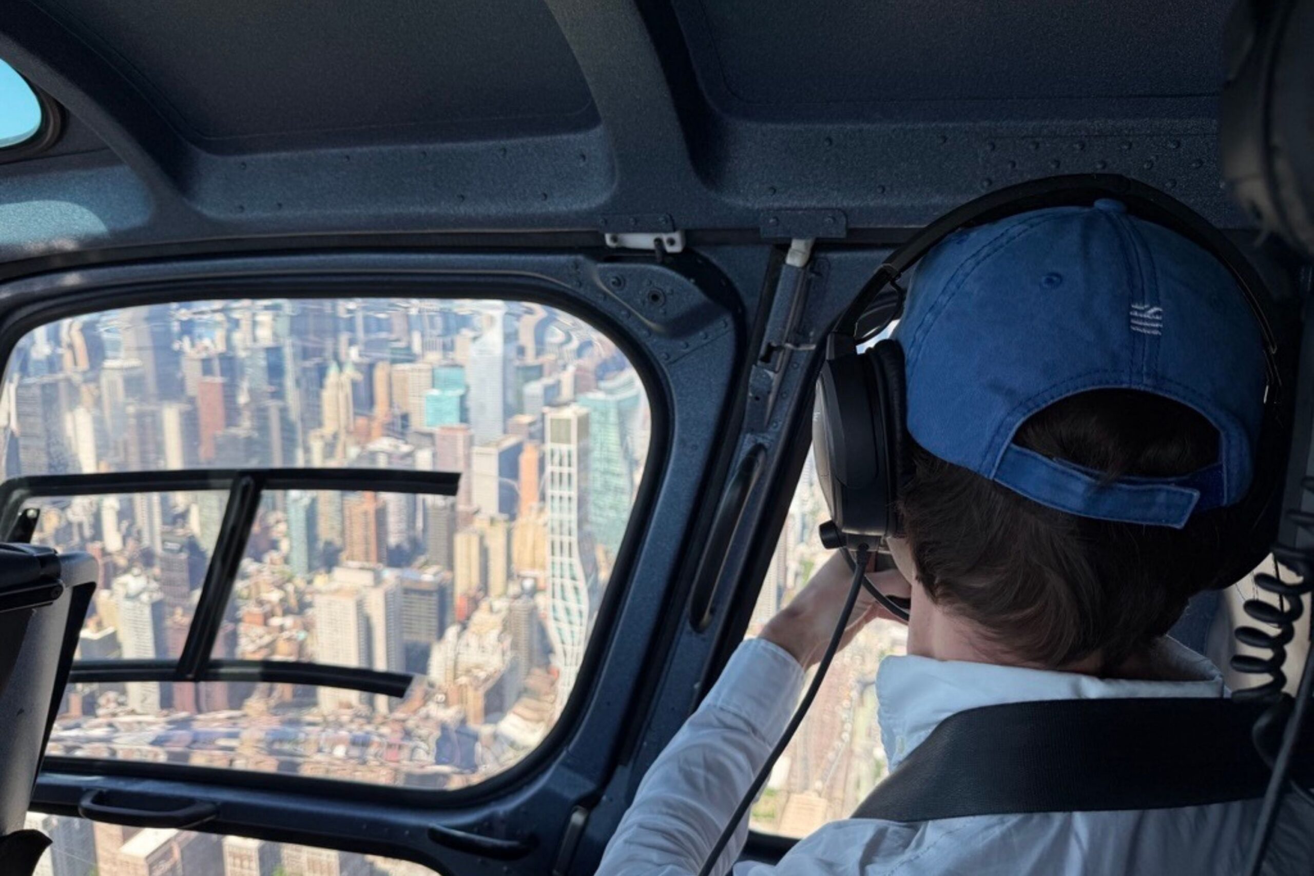 Guest wearing The William Vale hat taking photo of Manhattan from helicopter